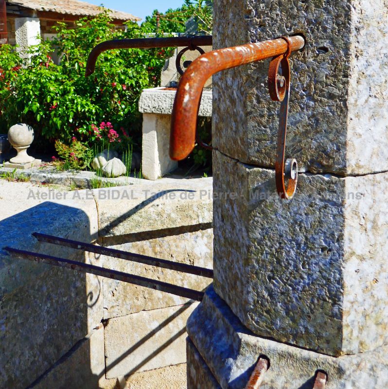 Detail of the forged water outlet from our natural stone fountain of Provence.