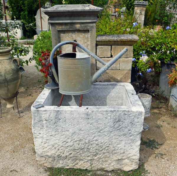 Small wall fountain in stone | Outdoor fountain with a massive stone trough.