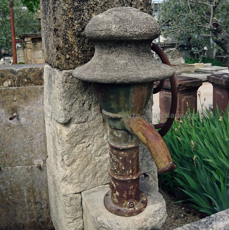 Decorative garden fountain with antique stone trough and antique manual water pump - Atelier Alain BIDAL .