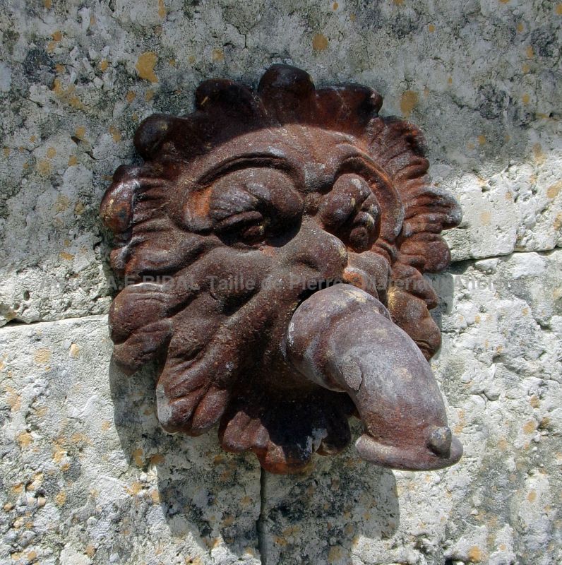 Antique cast-iron mascaron on our wall fountain in aged and patinated stone - Atelier Alain BIDAL - Provence