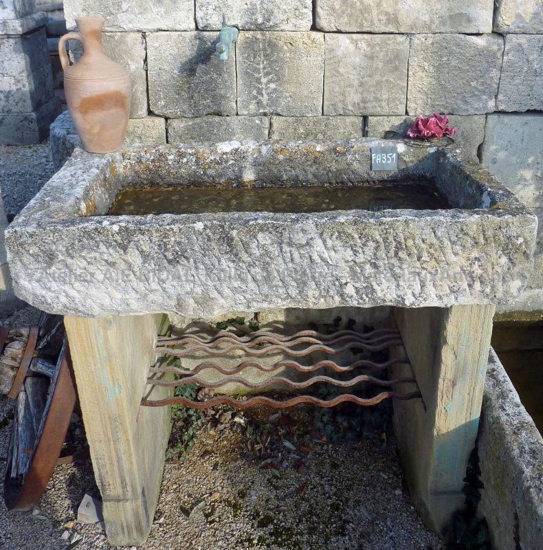 Antique monolith stone sink on our garden wall fountain in old stones.