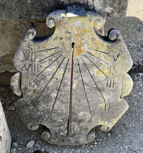Sundial made of natural stone that is naturally weathered - sundial with Roman numerals.