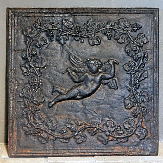 Superbe ancienne plaque de cheminée en fonte représentant Cupidon - accessoires cheminée en fonte ancienne.