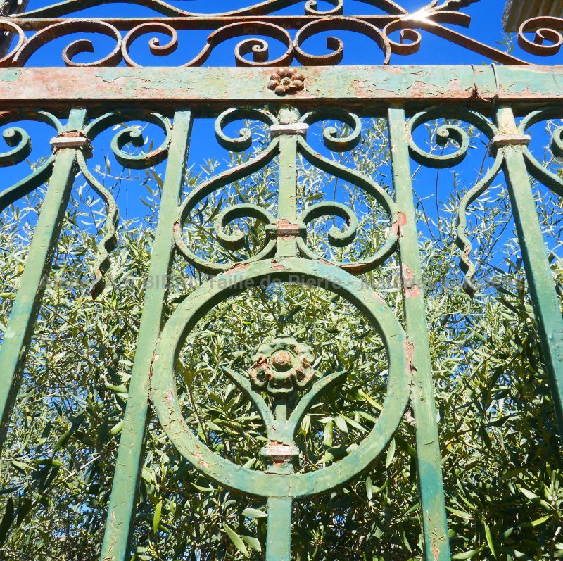 Old gate with two half-paneled doors in wrought iron - beautiful reclaimed gate in wrought iron painted in green