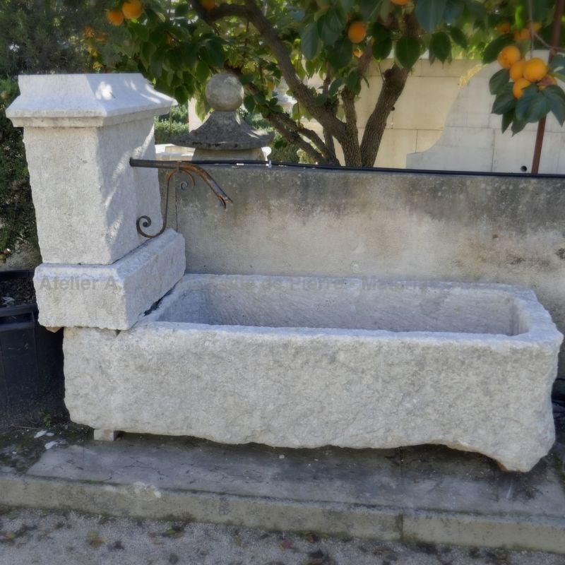 Fontaine campagnarde en pierre blanche pour aménagement du jardin à l'ancienne.