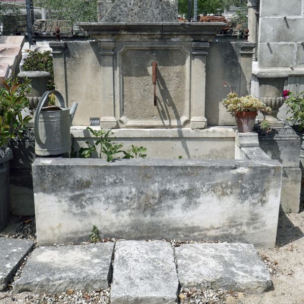 Wall fountain with decorative pediment | Antique garden fountain made of wrought iron and ancient stone.