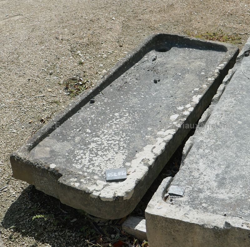 Ancienne pile provençale en pierre patinée : évier long et plat en pierre pour cuisine d'été.