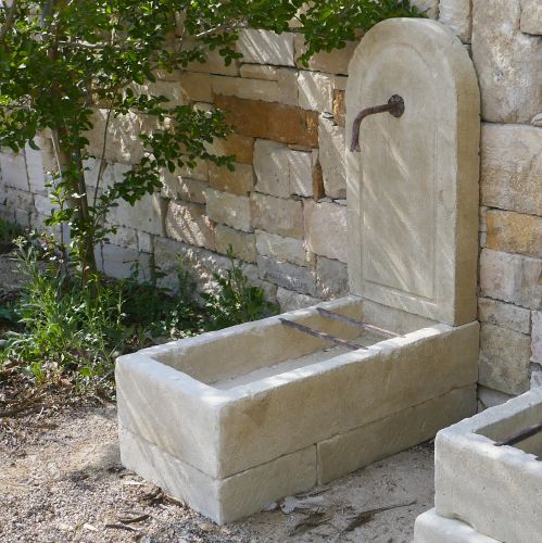 Borne à eau en pierre provençale : une petite fontaine rustique en pierre naturelle