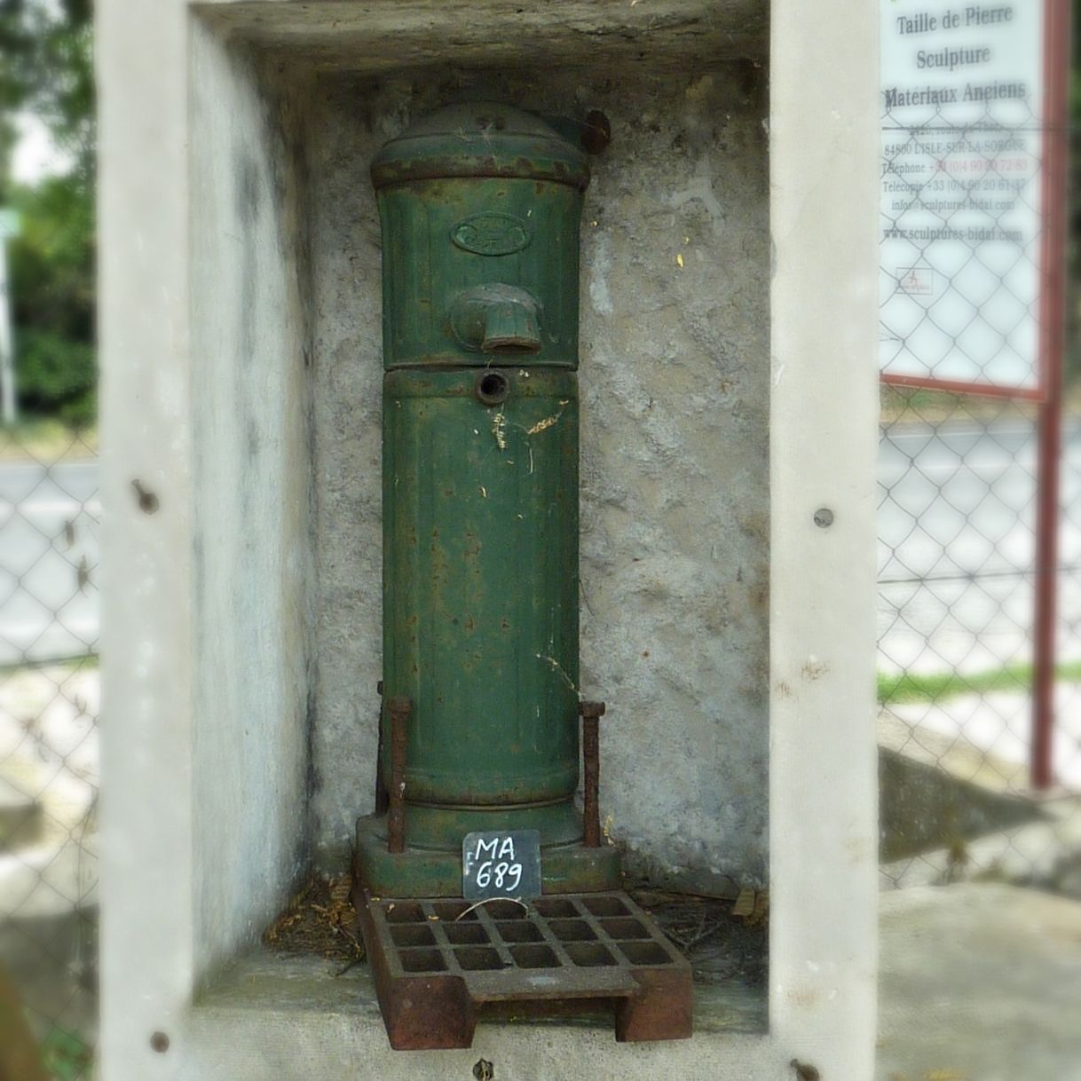Une pompe manuelle en fonte ancienne sur socles- ancienne pompe à eau.