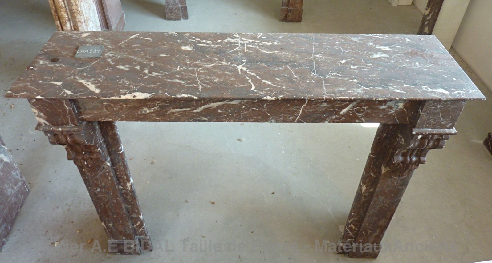 Cheminée marbre rouge veiné de blanc et de gris.