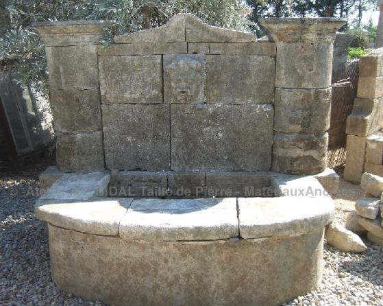 Fontaine en pierres anciennes avec tête de Bacchus