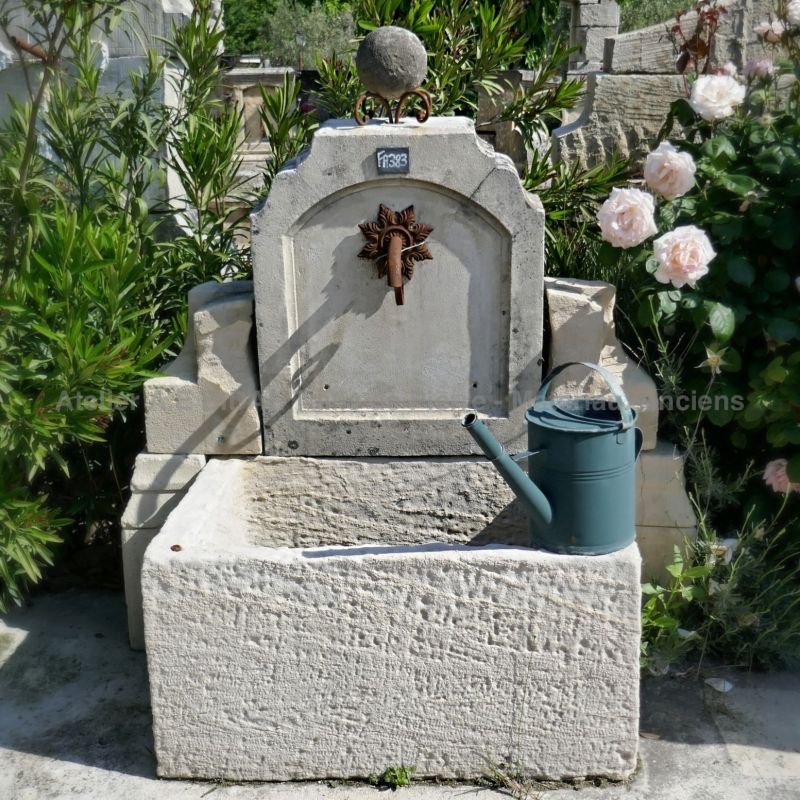 This charming wall fountain crafted in old stones is a beautiful wall fountain for the garden.