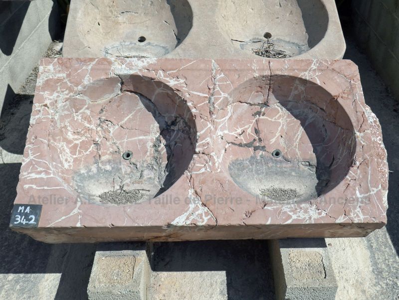 An old sink made of red stone veined with white - antique sink with double marble washbasin.