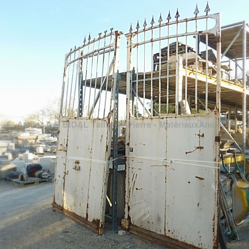 Antique wrought iron gate with a small gate for pedestrian passage.