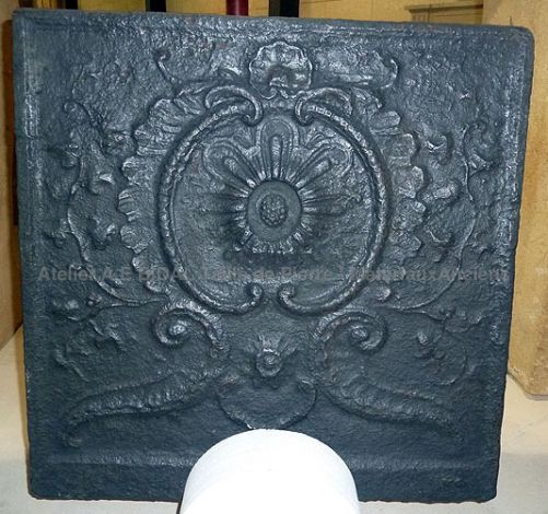 Une plaque de cheminée en fonte de charme décorée de fleurs et de végétaux dans un style baroque - accessoires cheminée 18ème.
