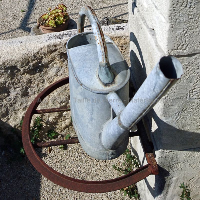 Detail of the beautiful old ironwork that serves as a bucket rest on our old stone wall fountain - Atelier Alain BIDAL.