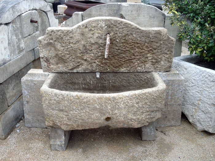 Une fontaine de jardin avec bac massif d'un style très authentique - belle petite fontaine murale d'extérieur.