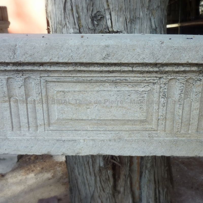 Cheminée ancienne en pierre - une cheminée Louis 16 à décoration géométrique.