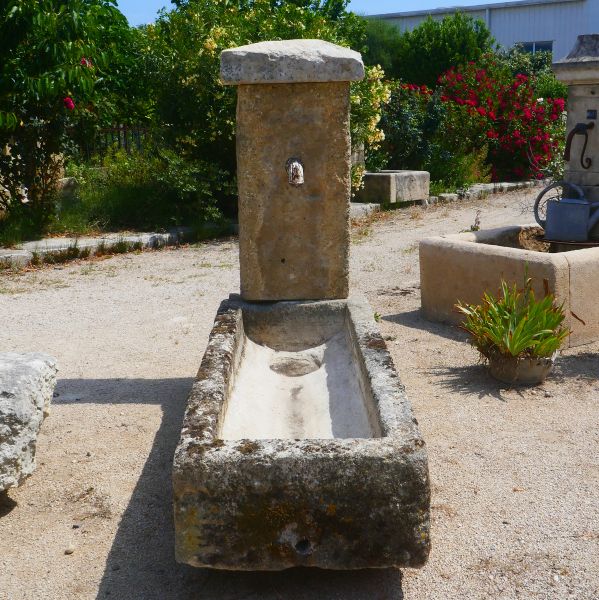 Wall fountain with a rustic appearance : outdoor fountain with old trough for a Provençal style garden.
