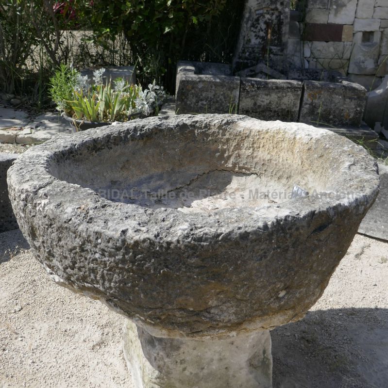 Circular basin in stone : an antique large round stone trough that can be used as a planter.