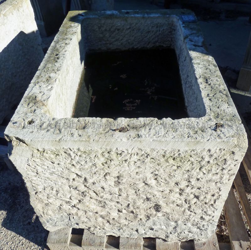 Large rectangular basin : an antique trough in stone with rustic edges.
