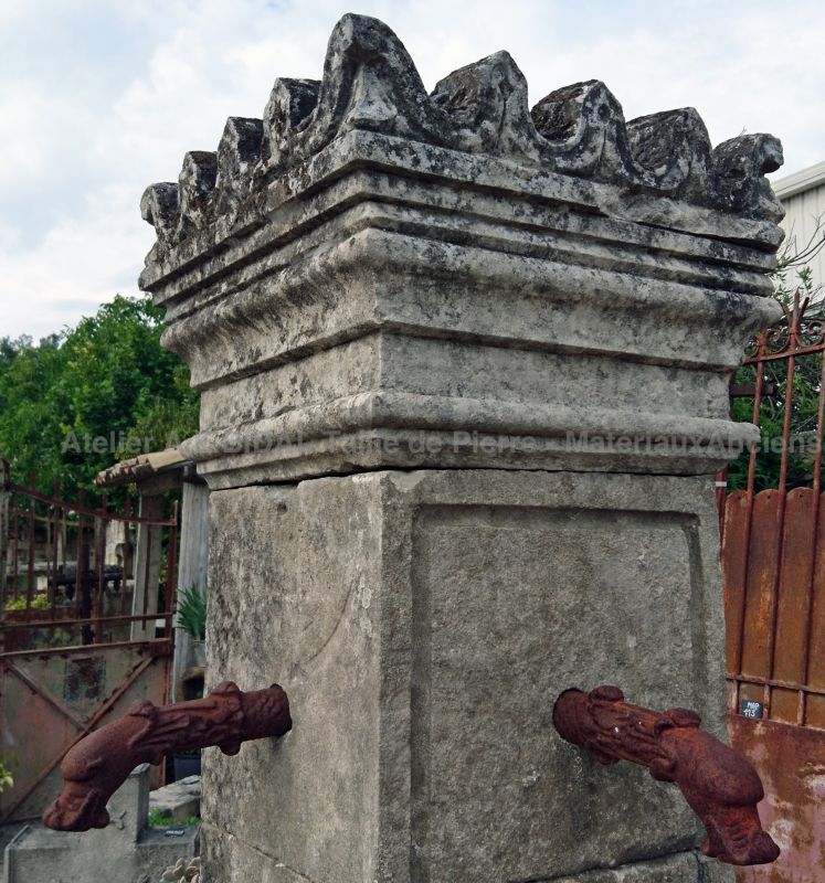 Beautiful central fountain with four forged iron water outlets | Stone fountain with square basin.