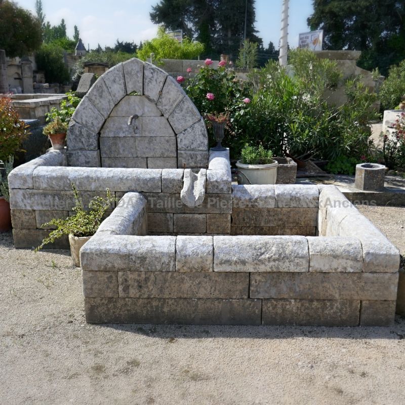 Fontaine murale pour jardin en vieilles pierres en vente chez le spécialiste des fontaines de Jardin en pierre : Atelier Alain Bidal en Provence.