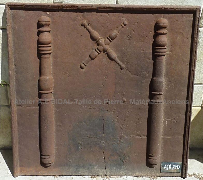 Une plaque de cheminée en fonte avec décoration pilier ancien (x2) et croix de Saint André en relief.