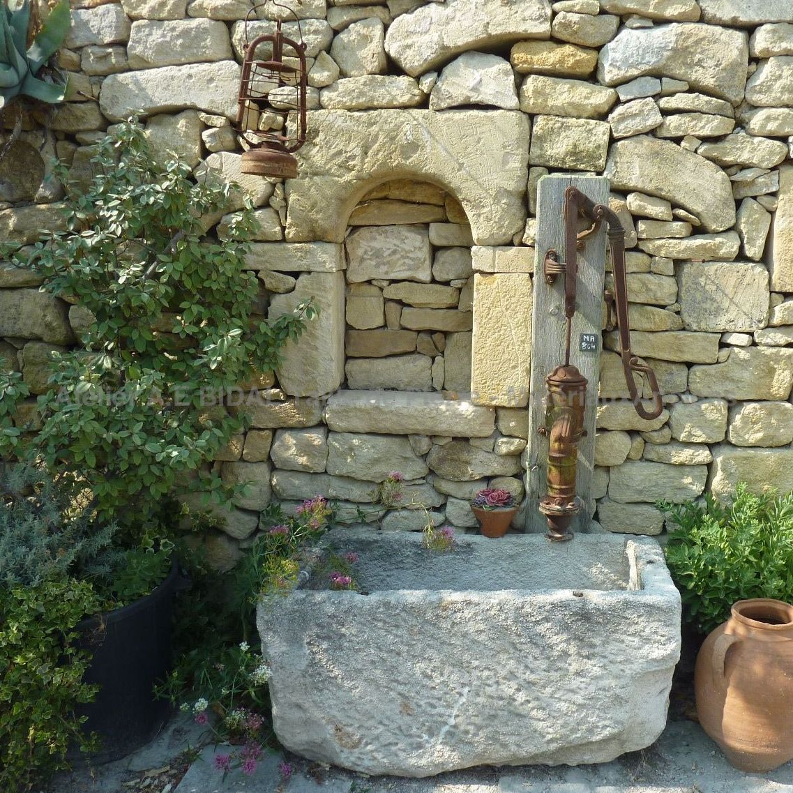 Hand pump for small garden fountain with basin.