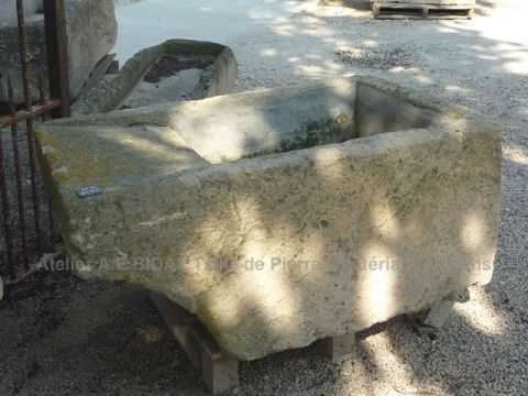 Lavoir ancien en pierre de taille dure, lavoir d'extérieur de couleur ocre.