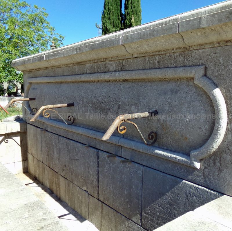 Détail des 3 anciennes sorties d'eau en fer forgé sur le fronton de notre large fontaine murale en pierres vieillies