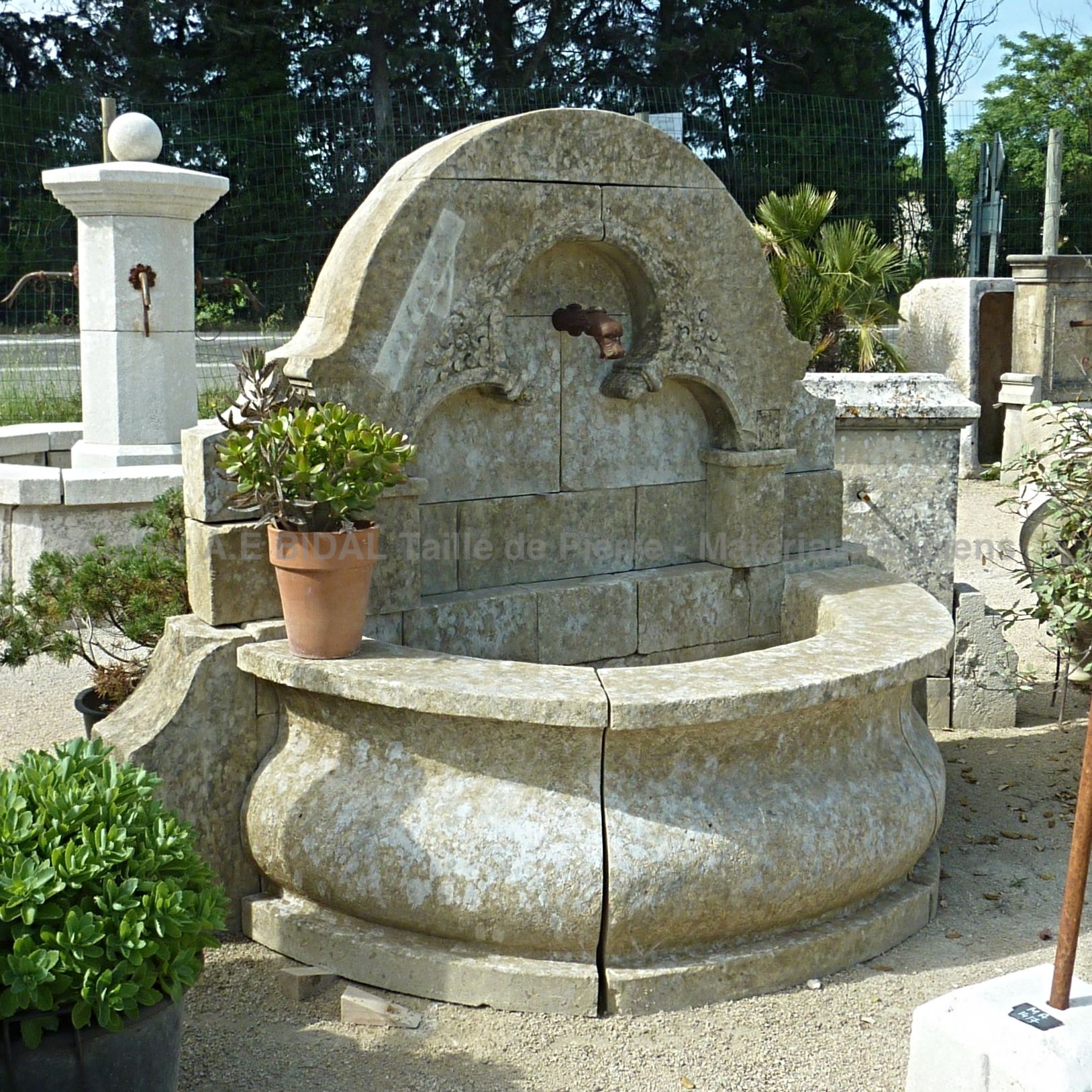 Large fontaine de jardin en pierre ancienne avec bassin rond et fronton sculpté à la main - Pièce unique de chez AE Bidal, Provence.