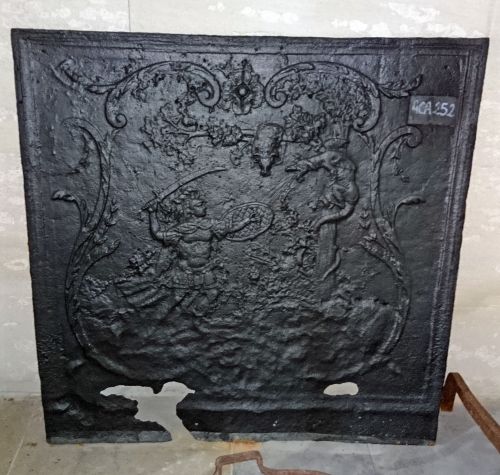 Plaque de cheminée en fonte ancienne représentant une scène d'affrontement dans la mythologie.