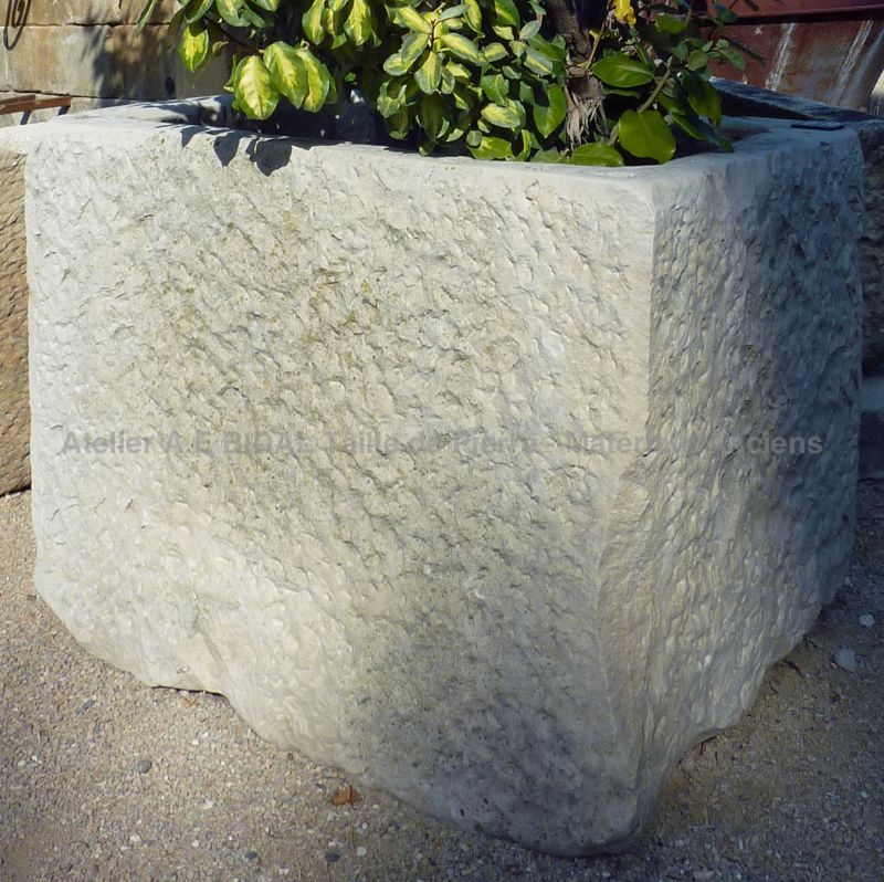 Massif et joli bac ancien en pierre blanche, un bac cubique de décoration de jardin.