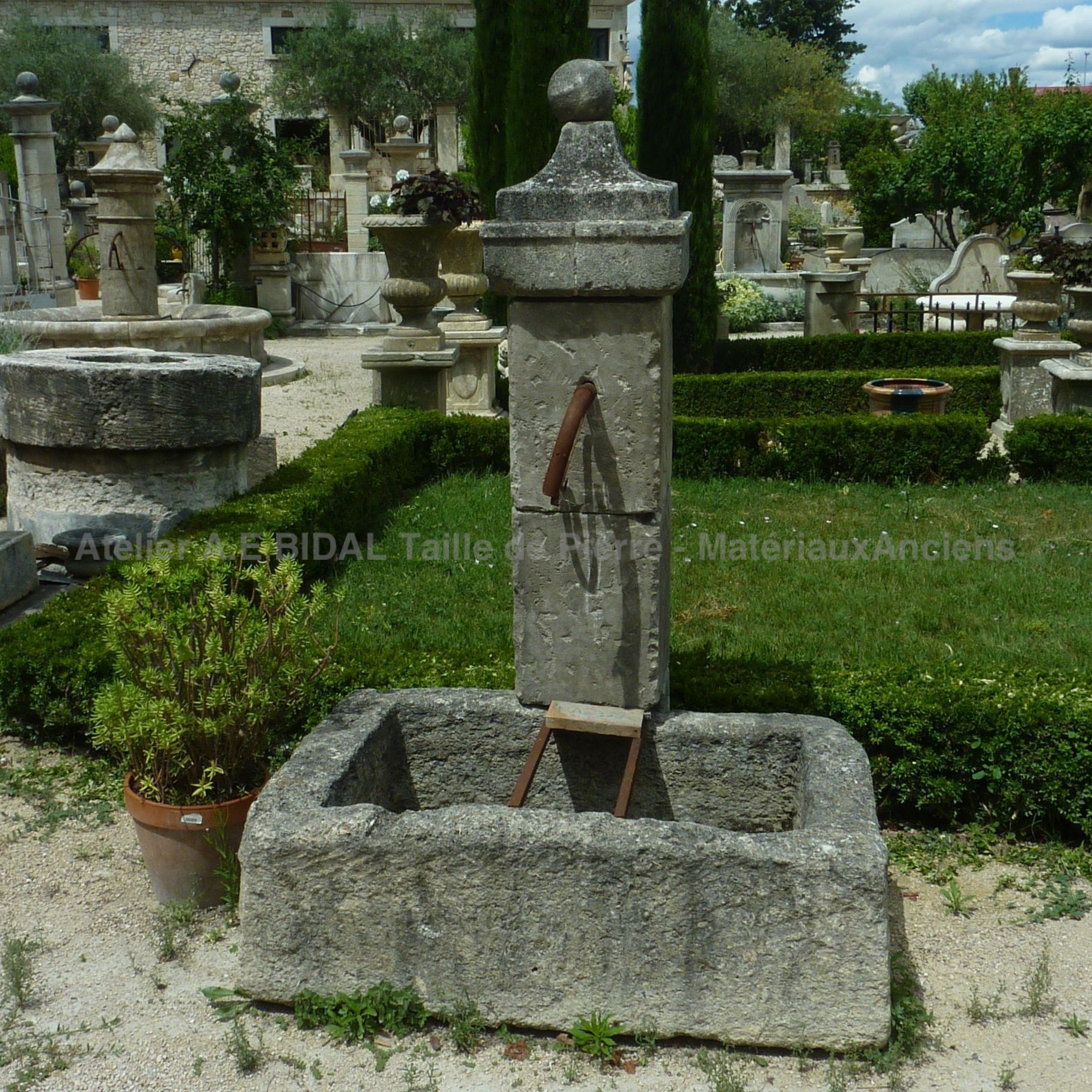 Fontaine murale avec bac et repose-seau - une ancienne fontaine décorative d'extérieur.