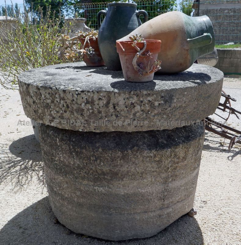 Antique grinding wheel in stone garden decoration in reclaimed stone