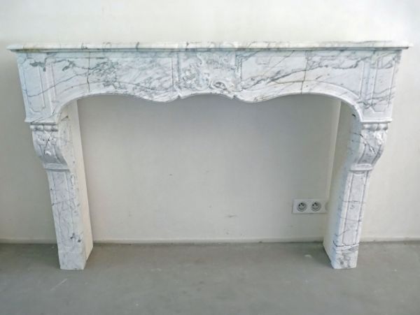 Cheminée en marbre blanc joliement travaillée et décorée - Cheminée ancienne d'une allure élégante.