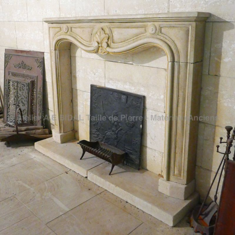 Antique patinated stone veneering fireplace with base : Atelier Alain BIDAL, Provence
