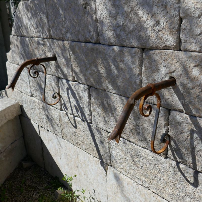 Détails du fronton en pierre ancienne et des 2 sorties d'eau en fer forgé sur notre large fontaine murale de Provence.