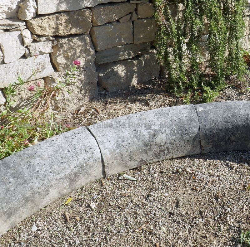 Détail des margelles arrondies de notre bassin de jardin en vieilles pierres patinées