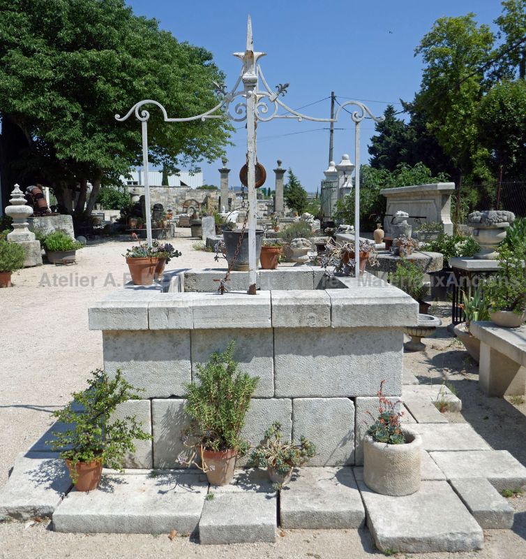 Garden well in stone with its stunning decorative top in forged wrought iron