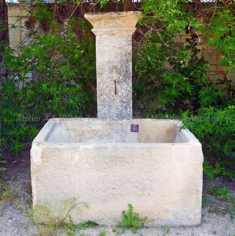 Old stone garden fountain with large trough for sale at Atelier Alain Bidal, Provence.