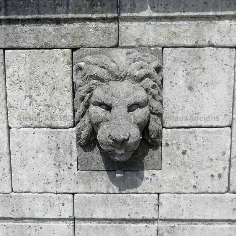 Hand-sculpted lion's head on our large patinated stone wall fountain