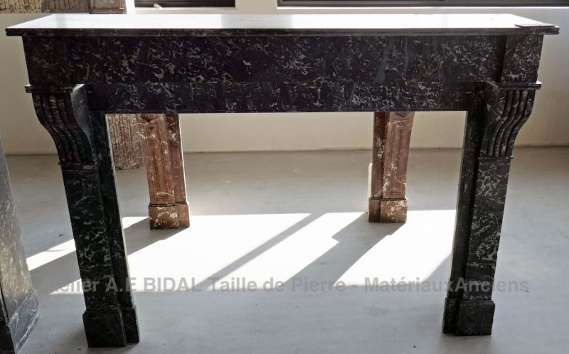 Cheminée marbre noir richement décorée - une cheminée ancienne fastueuse.