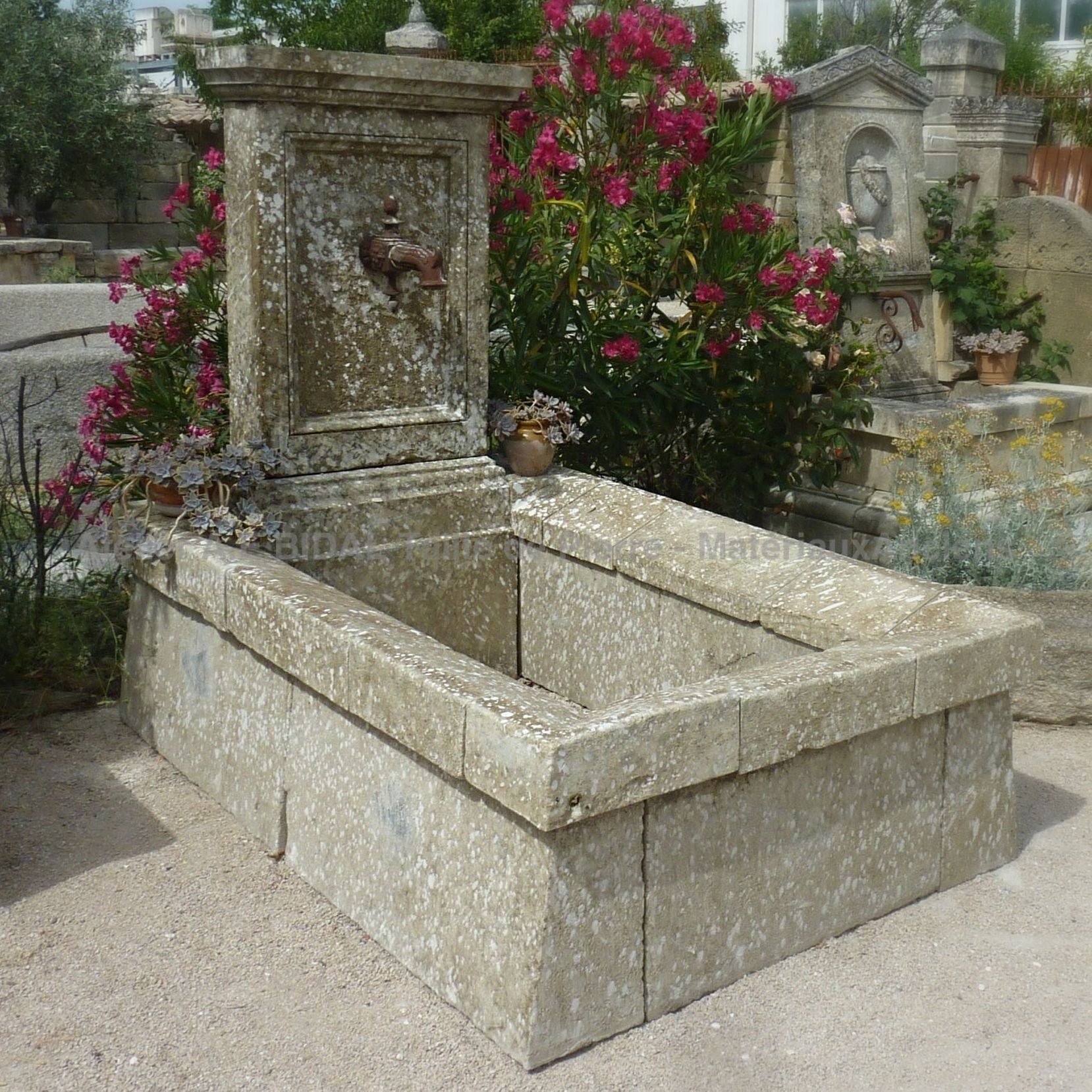 Longue fontaine à eau de jardin en pierres anciennes pour un aménagement plein de charme !