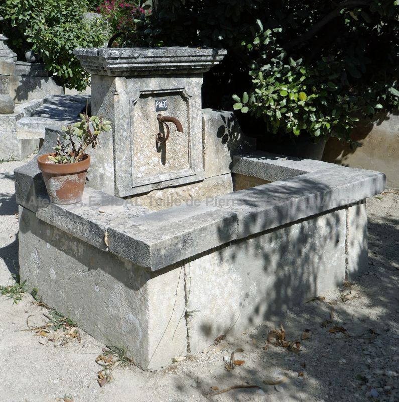 Small charming Provencal fountain: garden fountain made of old stone with a nice pediment.