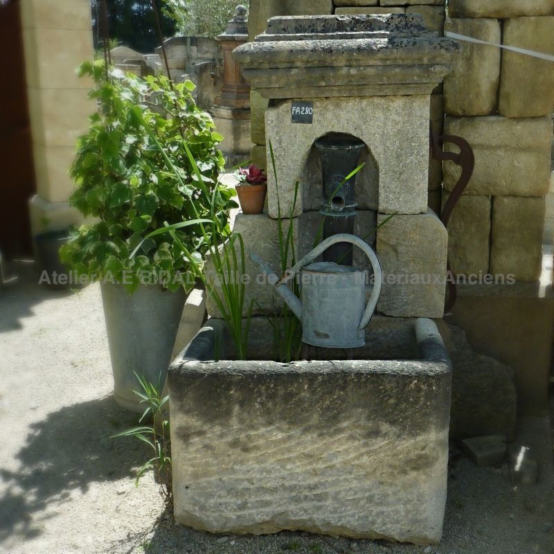 Garden fountain with hand pump | Old fountain with rectangular stone trough and manual cast iron pump.