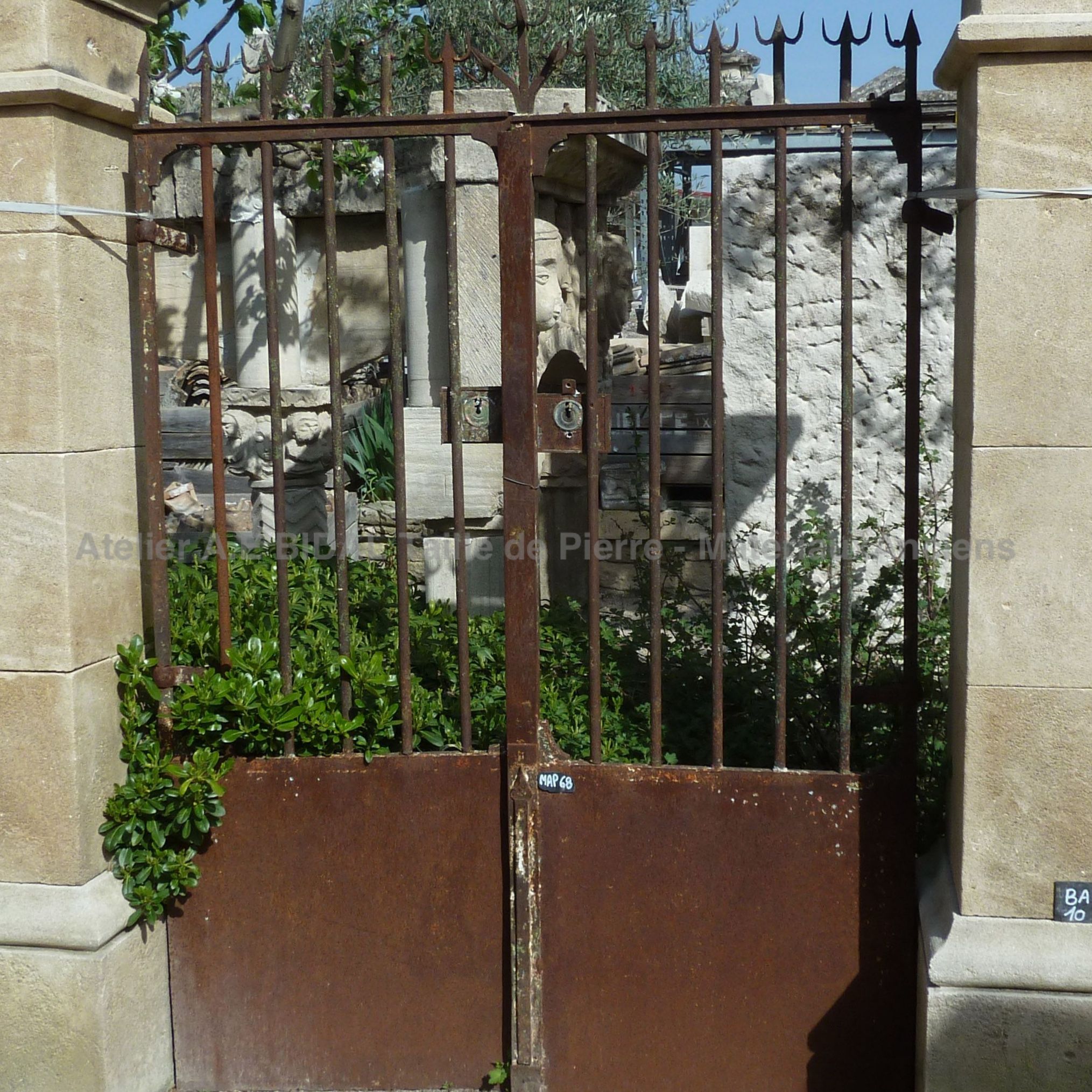Small old wrought iron gate with 2 gates - pedestrian gate made of iron .