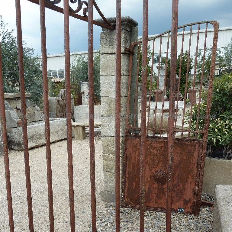 Portail ancien - un portail en fer forgé décoré de manière artisanale de jolies rosaces.