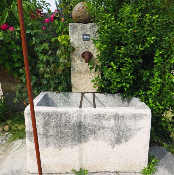 Fontaine de jardin ancienne en pierre avec bac ancien en vente chez Alain Bidal, tailleur de pierre en Provence.